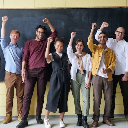 photo of a group of people lined up and raising one hand